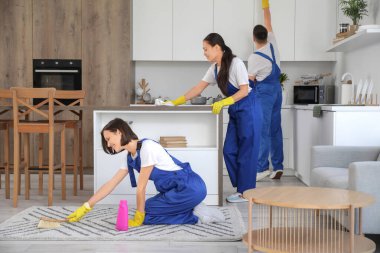 Genç hademeler mutfağı temizliyor.