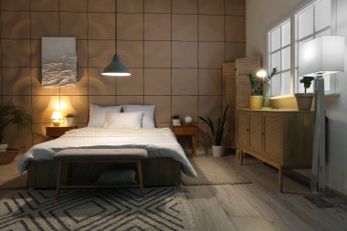 Yatak odasının içi, büyük yatak odası, çekmeceler, komodinlerle ve geceleri parlayan lambalarla dolu.