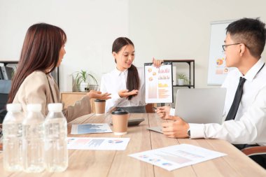 Ofisteki masada diyagramlarla çalışan Çinli işadamları