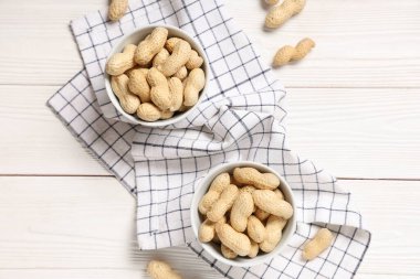 Beyaz ahşap arka planda soyulmamış fıstıklı kaseler