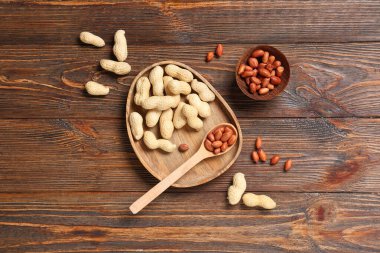 Soyulmamış fıstık tabağı ve ahşap arka planda soyulmuş fındık kasesi.