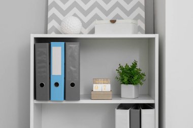 Klasörlü küp takvimi ve ofisteki ışık duvarının yanındaki rafa yerleştirin