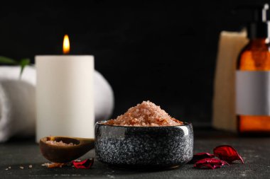 Siyah arka planda deniz tuzu ve taç yapraklarıyla kaplıcada güzel bir kompozisyon, yakın plan.