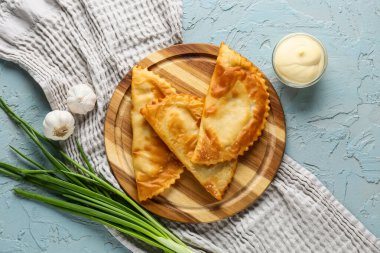 Lezzetli çizburgerler, taze sebzeler ve gri grunge masasında sos.