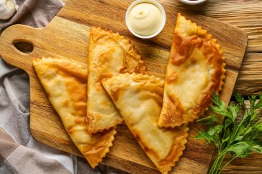 Lezzetli çizburgerler, taze maydanoz ve ahşap masadaki sos.