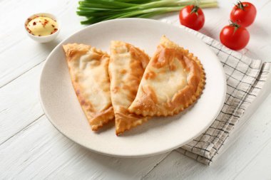 Beyaz ahşap arka planda lezzetli chebureks tabağı