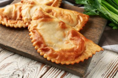 Ahşap arka planda lezzetli cheburekler, yakın plan