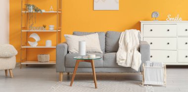 İçinde kanepe, masa ve raf ünitesi olan bir oturma odası.