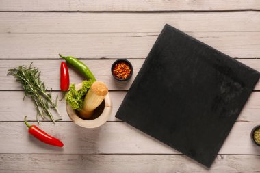 Tahta tahtayla kompozisyon ve hafif ahşap arka planda taze baharatlar.