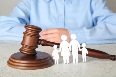 Aile figürleri ve ışık masasında yargıç tokmağı olan kadın.