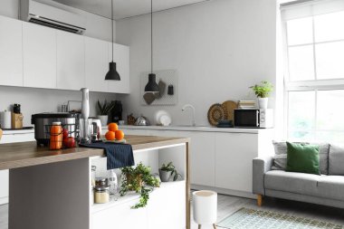 Ahşap masadaki modern aletlerle aydınlık mutfağın içinde.