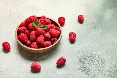 Taze ahududu ve nane arkaplanlı kase, yakın plan.