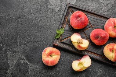 Tatlı incir şeftalili tahta ve siyah arkaplanda nane.