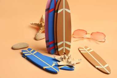 Sarı arka planda farklı mini sörf tahtaları ve deniz yıldızları