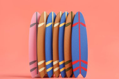 Pembe arka planda farklı mini sörf tahtaları