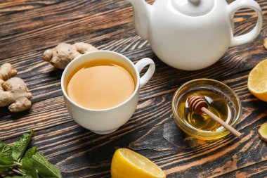 Bir fincan zencefilli çay ve bal, ahşap zemin üzerinde.