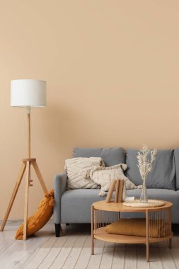 Rahat gri kanepesi ve ahşap sehpası olan modern oturma odasının içinde.