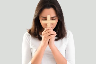 Genç bayan arka planda haç ile dua ediyor, yakın plan