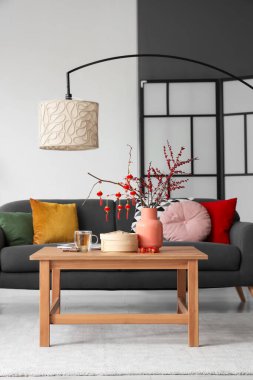 Çin Yeni Yıl kutlamaları için kanepe, masa ve dekorla oturma odasının içinde.