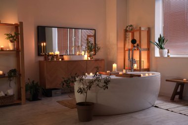 Geceleri yanan mumlar, lavabo ve küvetin olduğu banyonun içi.