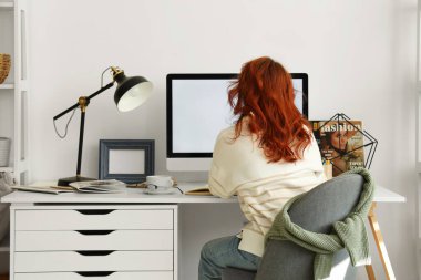 Işık ofisindeki şık işyerinin yanında oturan genç kadın.