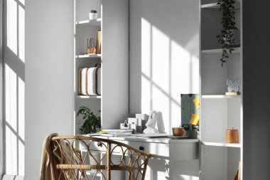 Çalışma yeri, sandalye, raf ünitesi ve ev bitkisi olan şık bir ofis.