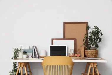 Konforlu işyeri, sandalye, ev bitkileri ve modern dizüstü bilgisayarı olan ofis içi