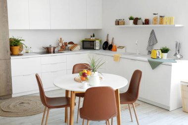 Mutfağın içinde yemek masası ve tezgahları var.