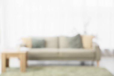 Gri kanepeli, masalı ve pencereli oturma odasının bulanık görüntüsü