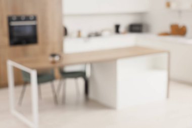 Beyaz tezgahlı ve yemek masalı aydınlık mutfağın bulanık görüntüsü