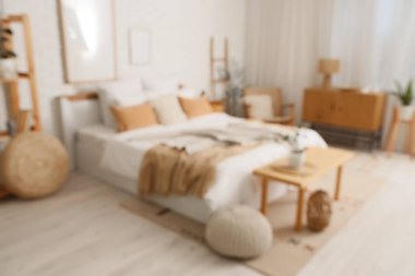 Büyük yataklı, ahşap banklı ve puflu rahat yatak odasının bulanık manzarası