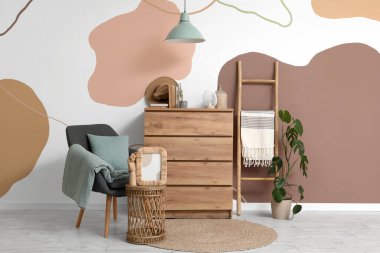 Gri koltuklu, sehpası ve şifoniyeri olan şık bir oturma odası.