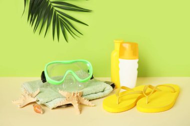 Havlu, güneş kremi şişeleri ve plaj aksesuarları.