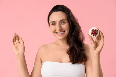 Pembe arka planda banyo bombası olan güzel bir kadın.