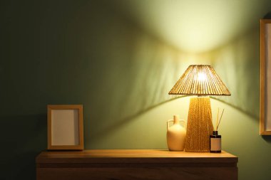 Klozette sazlık dağıtıcı, vazo ve boş çerçeve ile parlayan lamba
