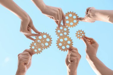 Gök yüzüne karşı ahşap dişlileri olan birçok el, alt görünüm