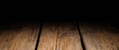 Wooden table top on black background