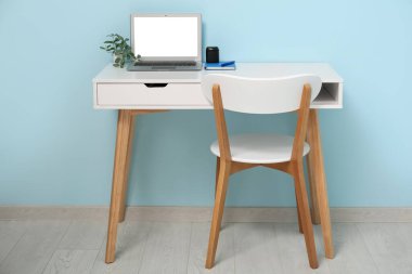 Laptop, masa ve sandalyeli rahat bir iş yeri