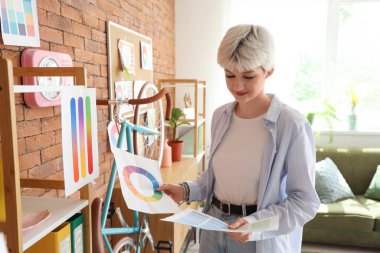 Ofiste renk paletleri ile çalışan kadın grafik tasarımcısı