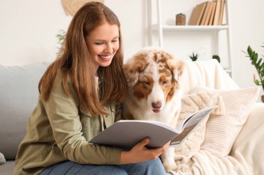 Evde şirin bir Avustralya çoban köpeği dergisi olan genç bir kadın var.