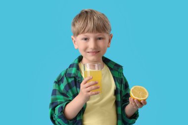 Mavi arka planda limonata ve bir bardak limonata olan şirin bir çocuk.