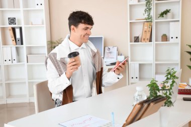 İş yerinde hesap makinesi ve bir fincan kahvesi olan bir muhasebeci.