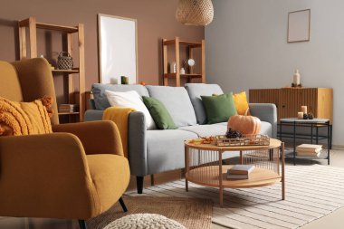 Oturma odasının sonbahar içleri kanepe, koltuk, sehpa ve dekorla dolu.