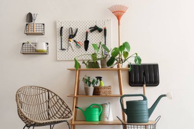 Bahçe aletleri, tahta ve koltuk bulunan atölyenin içi