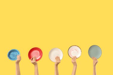 Sarı arka planda farklı plakalı kadın elleri