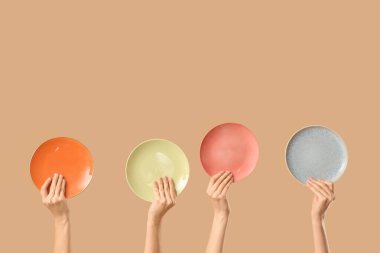 Bej arka planda farklı plakalı kadın elleri