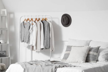 Yatak odasının iç tarafındaki yatak odasının yanındaki rafları ve elbiseleri topla.