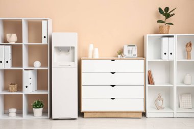 Modern su soğutucusu ve raf üniteleri olan şık bir ofis.