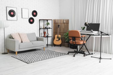 Çalışma yeri, müzik aletleri ve kanepesi olan kayıt stüdyosunun içi