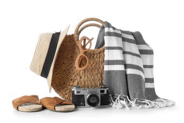 Wicker plaj çantası, fotoğraf makinesi ve aksesuarlar beyaz arka planda izole edilmiş, yakın plan.